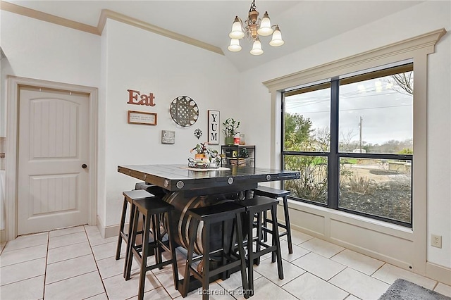 tiled dining room featuring ornamental molding and an inviting chandelier