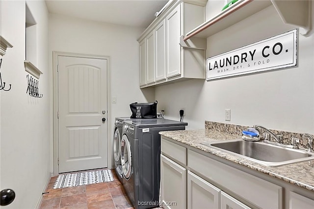 laundry room featuring cabinets, washing machine and dryer, and sink