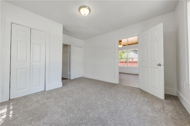 unfurnished bedroom with carpet flooring, baseboards, and a closet