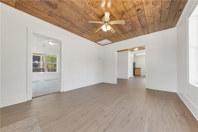 unfurnished room featuring a ceiling fan, baseboards, wooden ceiling, and wood finished floors