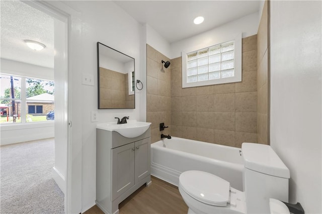full bath featuring toilet, vanity, and tub / shower combination