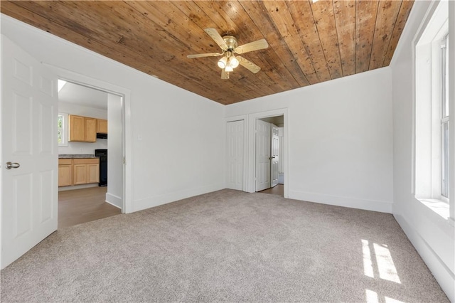 unfurnished bedroom featuring wooden ceiling, light carpet, baseboards, and a ceiling fan