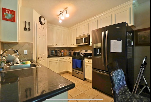 2401 Woodbend Dr, Bryan, TX 77803 - kitchen featuring appliances with stainless steel finishes, light tile patterned floors, dark countertops, white cabinets, and tasteful backsplash