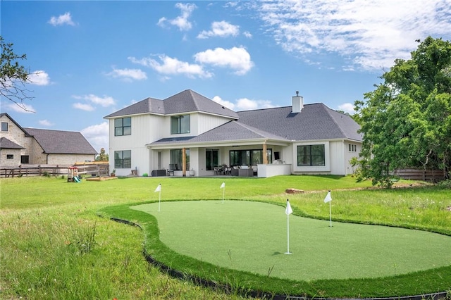 6038 Rain Meadow Dr, College Station, TX 77845 - back of house featuring an area to practice putting, a chimney, outdoor lounge area, and a patio area