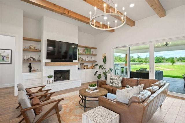 6038 Rain Meadow Dr, College Station, TX 77845 - living area featuring beam ceiling, light wood finished floors, a brick fireplace, a chandelier, and a high ceiling