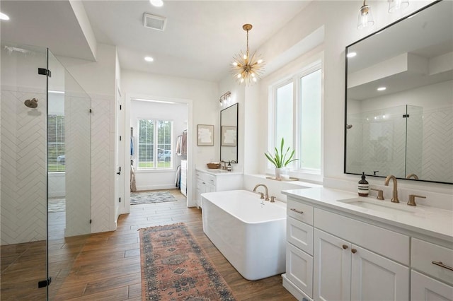 6038 Rain Meadow Dr, College Station, TX 77845 - bathroom with a shower stall, two vanities, a soaking tub, wood finished floors, and recessed lighting