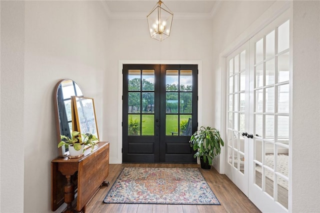 6038 Rain Meadow Dr, College Station, TX 77845 - entrance foyer with french doors, a chandelier, wood finished floors, and crown molding