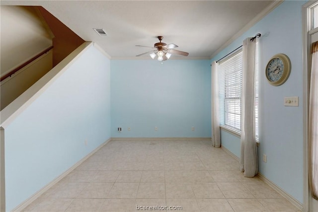 tiled empty room with ceiling fan and crown molding