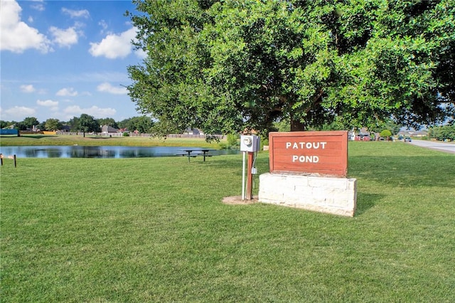 view of property's community featuring a lawn and a water view