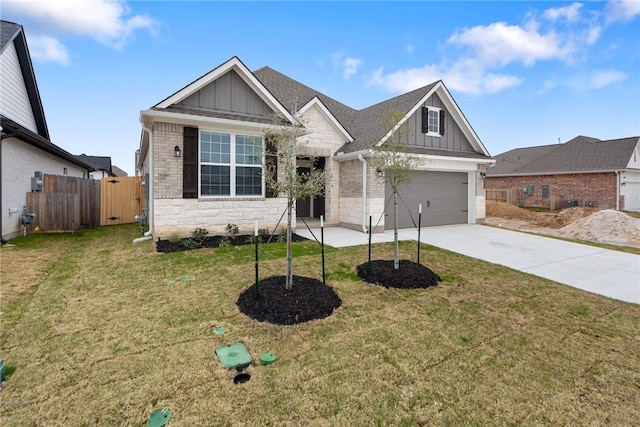 view of front of house featuring driveway, stone siding, fence, a front lawn, and board and batten siding