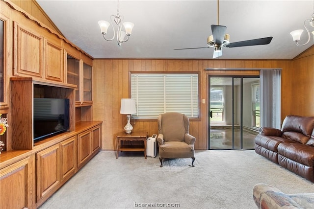 living room with wood walls, light carpet, radiator, ceiling fan with notable chandelier, and vaulted ceiling