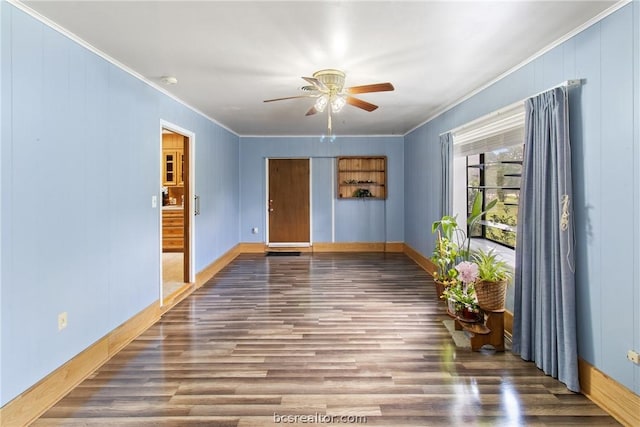 unfurnished room featuring dark hardwood / wood-style flooring, ornamental molding, and ceiling fan