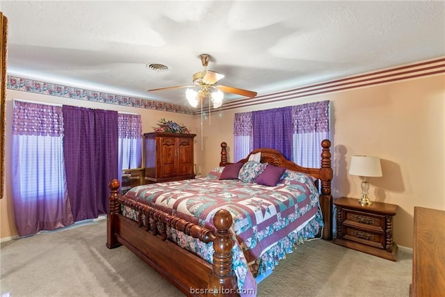 carpeted bedroom with a textured ceiling and ceiling fan