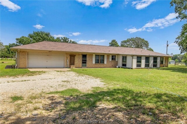 ranch-style house featuring a garage and a front lawn