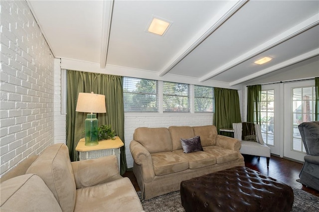 living room featuring vaulted ceiling with beams, dark hardwood / wood-style flooring, and brick wall