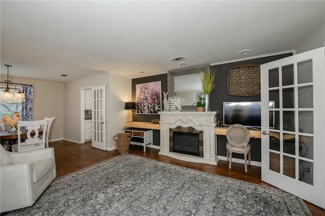 living room featuring a notable chandelier, dark wood-type flooring, and french doors