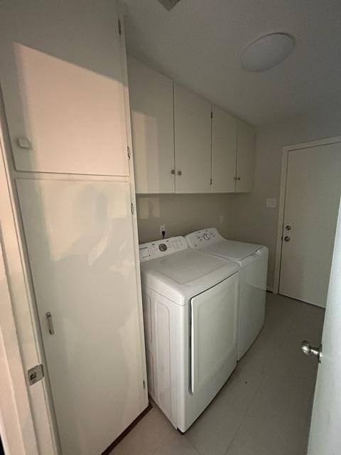 4200 Milam St, Bryan, TX 77801 - laundry area featuring washing machine and clothes dryer, cabinet space, and light tile patterned flooring