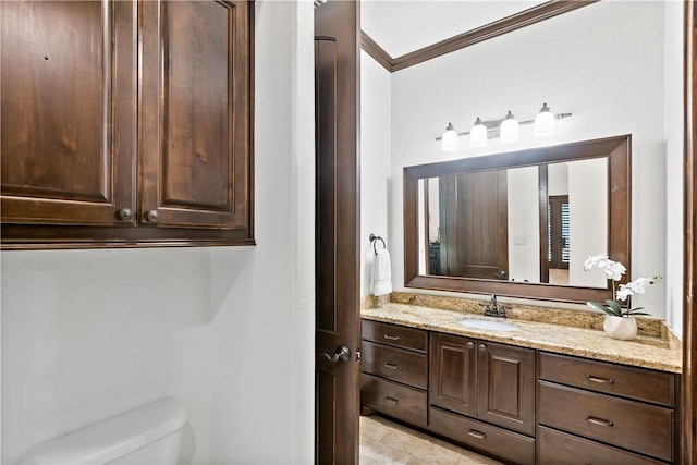 bathroom featuring vanity, toilet, and ornamental molding