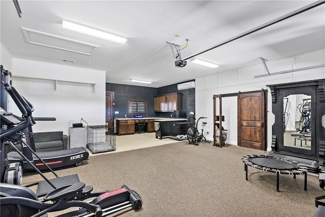 exercise room featuring visible vents, attic access, and a garage