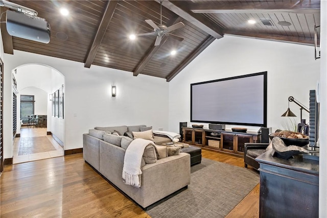 cinema room with wood finished floors, a ceiling fan, arched walkways, wood ceiling, and beamed ceiling