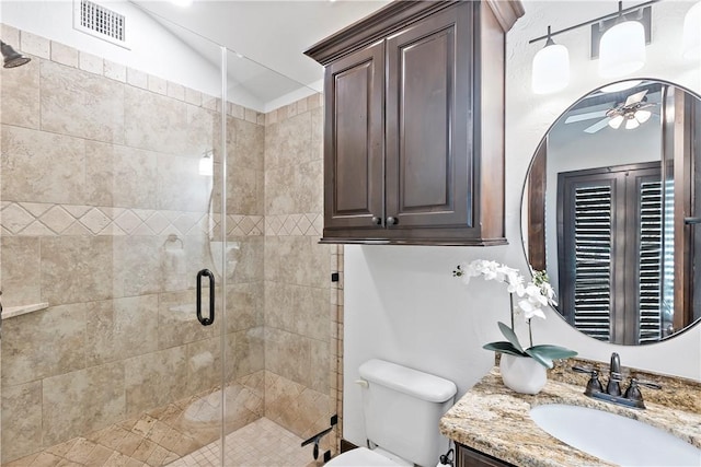 bathroom with visible vents, a stall shower, toilet, and vanity