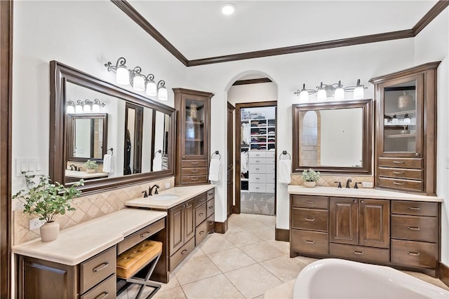 bathroom with tasteful backsplash, ornamental molding, two vanities, and a sink