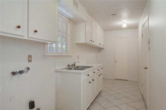 kitchen featuring light tile patterned floors, white cabinetry, and sink