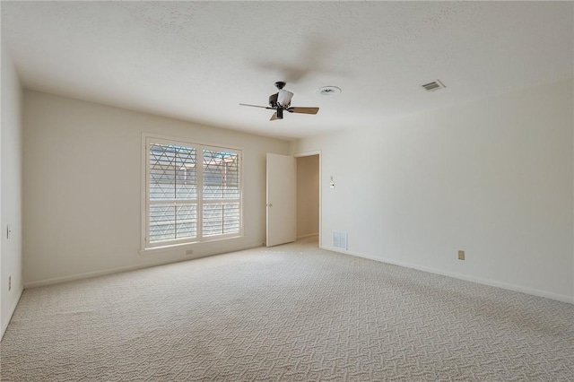 unfurnished room featuring light carpet, ceiling fan, and a textured ceiling