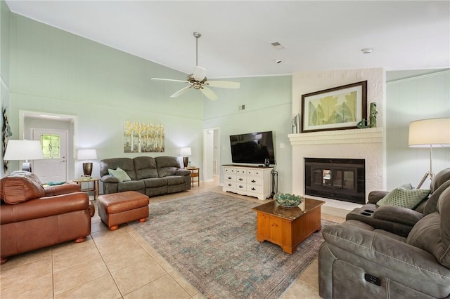 living room featuring visible vents, a ceiling fan, a brick fireplace, and light tile patterned floors