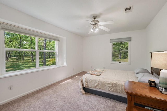 bedroom featuring visible vents, baseboards, carpet floors, and ceiling fan