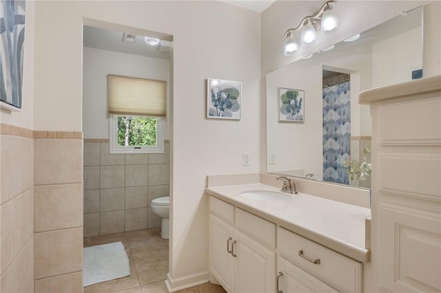 full bath featuring tile walls, tile patterned flooring, vanity, and toilet