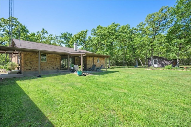 view of yard featuring an outbuilding, a shed, and a patio area