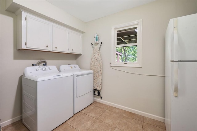 washroom with baseboards, cabinet space, independent washer and dryer, and light tile patterned flooring