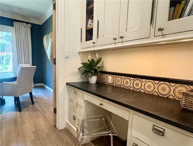 3911 Swarthmore St, Houston, TX 77005 - office area with ornamental molding, wood finished floors, baseboards, and built in desk