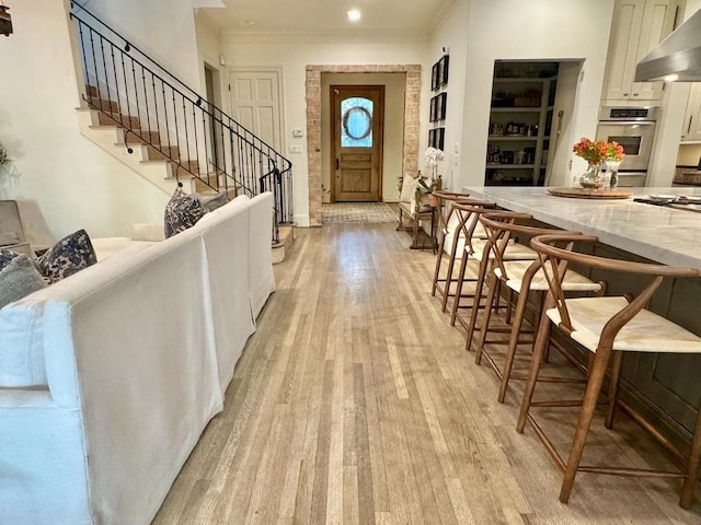3911 Swarthmore St, Houston, TX 77005 - foyer entrance featuring light wood-style flooring, crown molding, stairs, and recessed lighting
