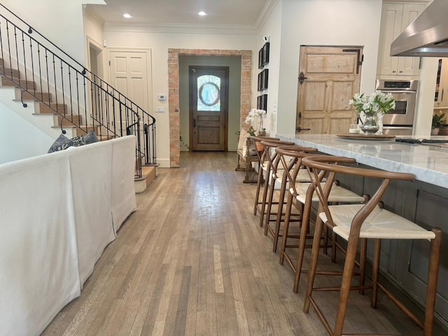 3911 Swarthmore St, Houston, TX 77005 - foyer entrance featuring crown molding, light wood finished floors, stairs, recessed lighting, and baseboards