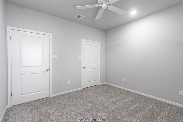 carpeted spare room with ceiling fan