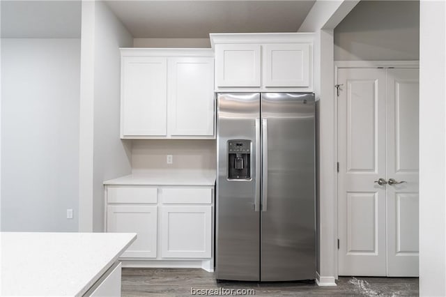 kitchen featuring hardwood / wood-style flooring, white cabinetry, and stainless steel refrigerator with ice dispenser