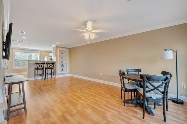 1725 Harvey Mitchell Pkwy, College Station, TX 77840 - dining space with visible vents, crown molding, light wood-style flooring, a ceiling fan, and baseboards