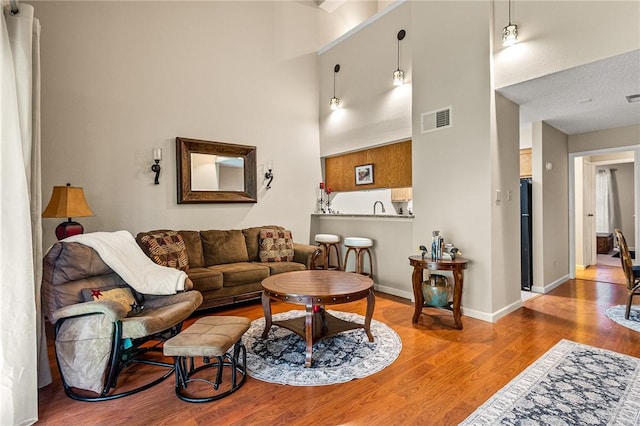 living room with a high ceiling, a textured ceiling, and hardwood / wood-style flooring