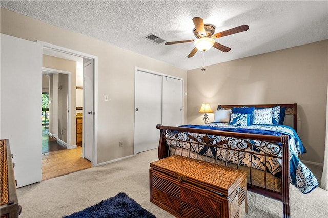 carpeted bedroom featuring ceiling fan, a closet, and a textured ceiling