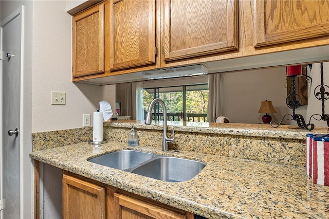 kitchen featuring light stone countertops and sink