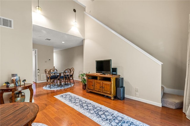 living room with hardwood / wood-style flooring and crown molding