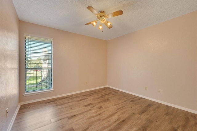 empty room featuring ceiling fan, light hardwood / wood-style flooring, and a textured ceiling