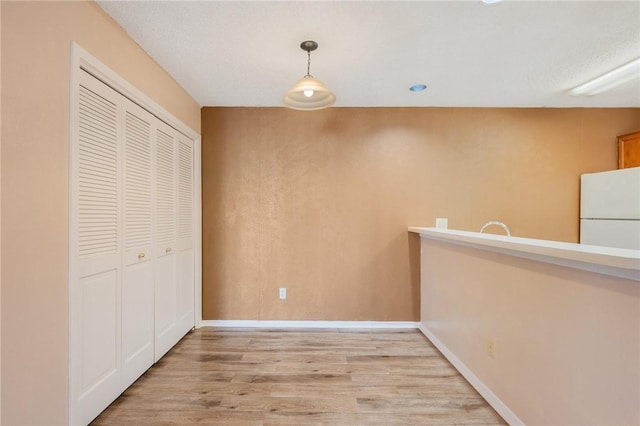 hallway with light hardwood / wood-style floors