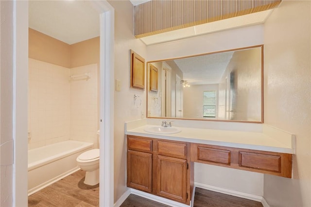 full bathroom with hardwood / wood-style floors, vanity, toilet, and tiled shower / bath combo