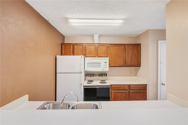 kitchen featuring a textured ceiling, sink, and white appliances