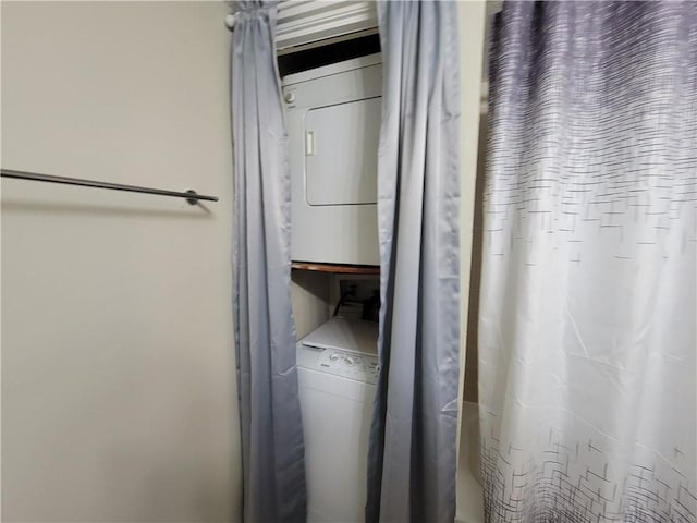 washroom featuring stacked washer / drying machine