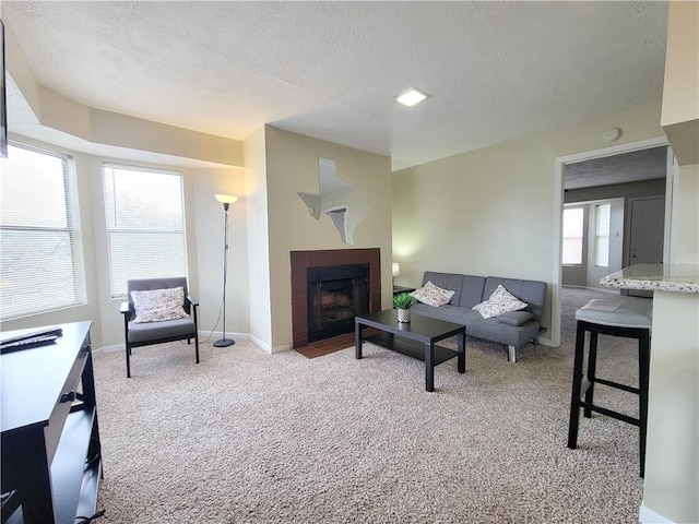 living room with a brick fireplace, light carpet, and a textured ceiling