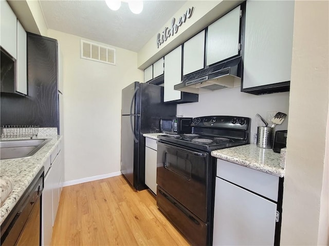 kitchen featuring white cabinetry, light stone counters, light hardwood / wood-style floors, and black appliances